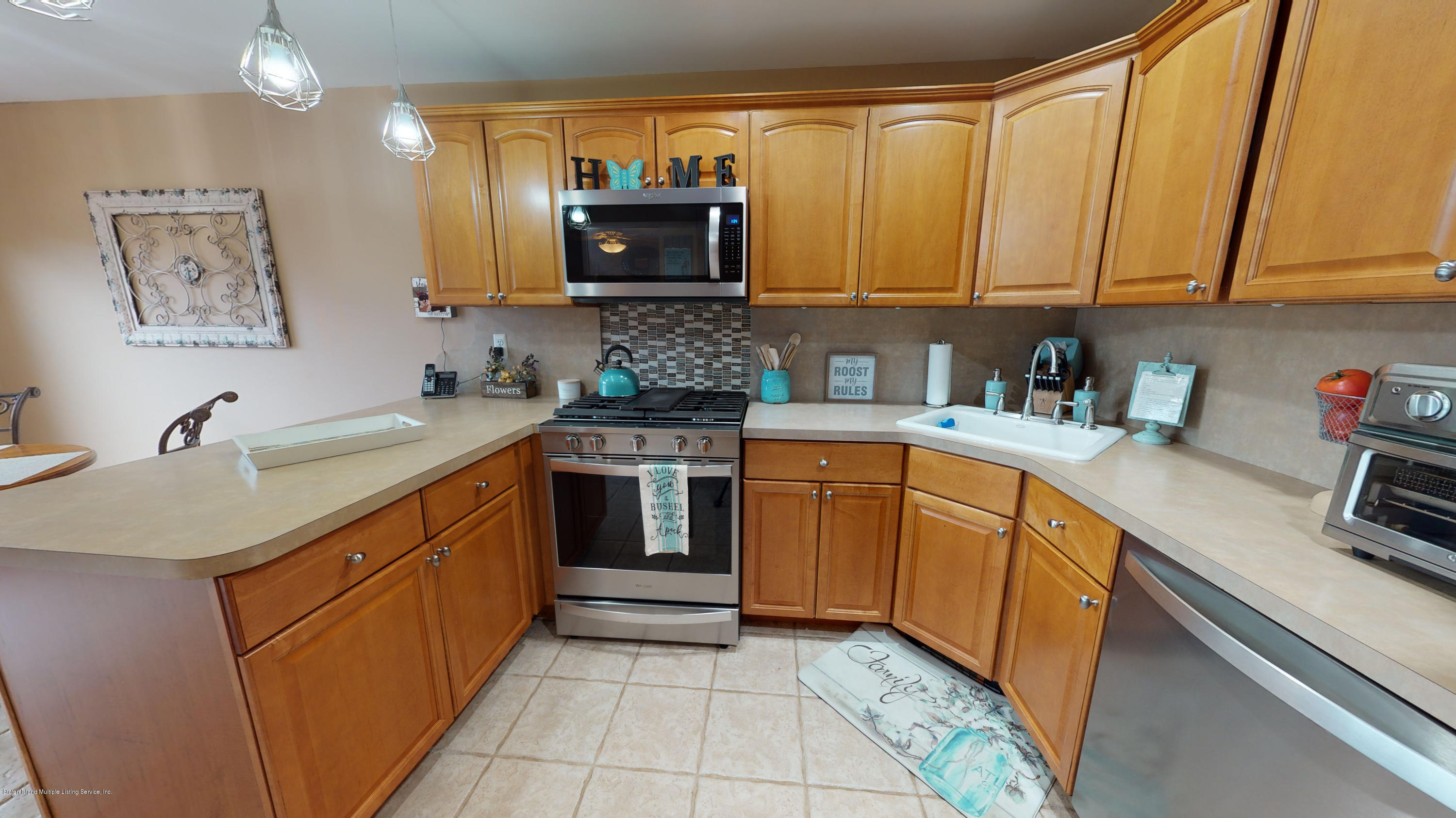 103 Covington Circle Staten Island, NY 10312 - Photo 2 of 21 a kitchen with stainless steel appliances a sink a stove a microwave a sink and cabinets