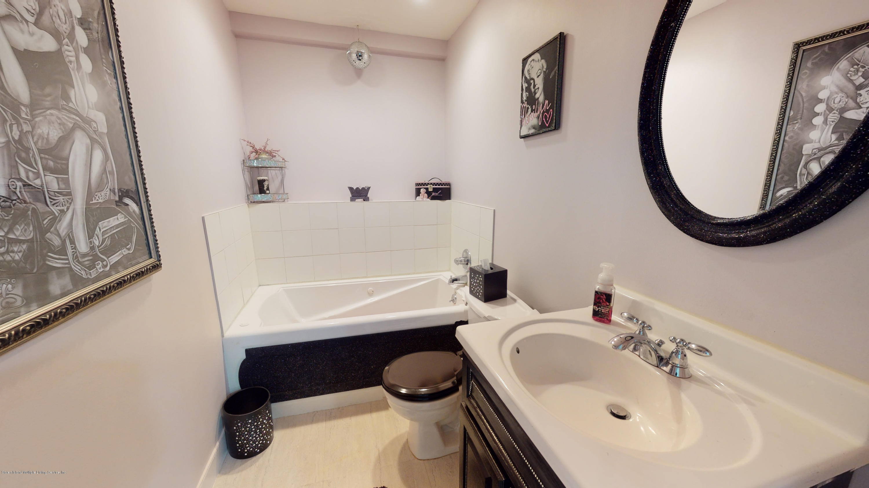 103 Covington Circle Staten Island, NY 10312 - Photo 18 of 21 a bathroom with a sink a toilet and a mirror