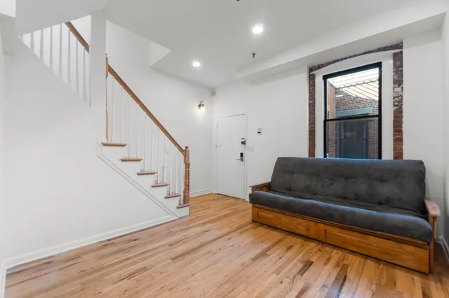 a living room with furniture and stairs