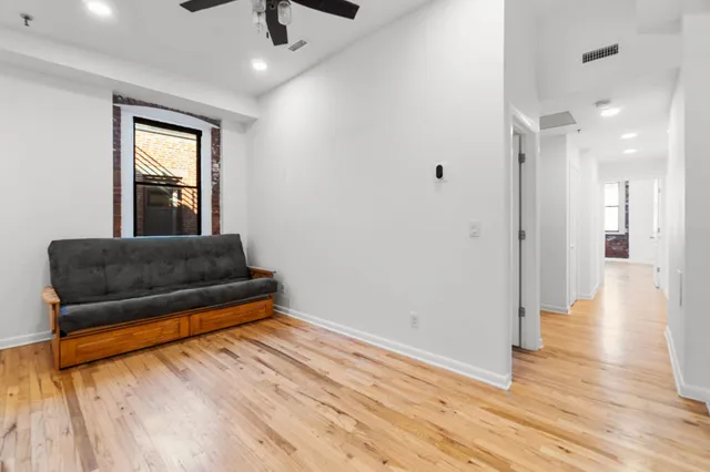 a living room with stainless steel appliances granite countertop furniture and a wooden floor