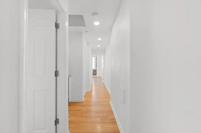a view of a hallway with wooden floor