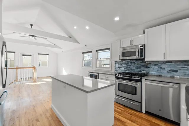 a kitchen with stainless steel appliances granite countertop a sink stove and microwave