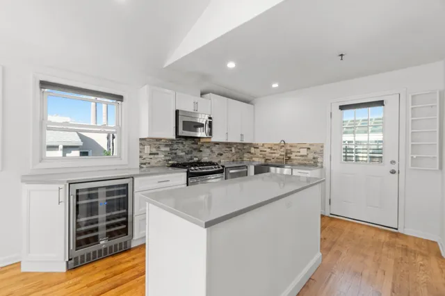 a kitchen with stainless steel appliances granite countertop a stove top oven a sink and a refrigerator