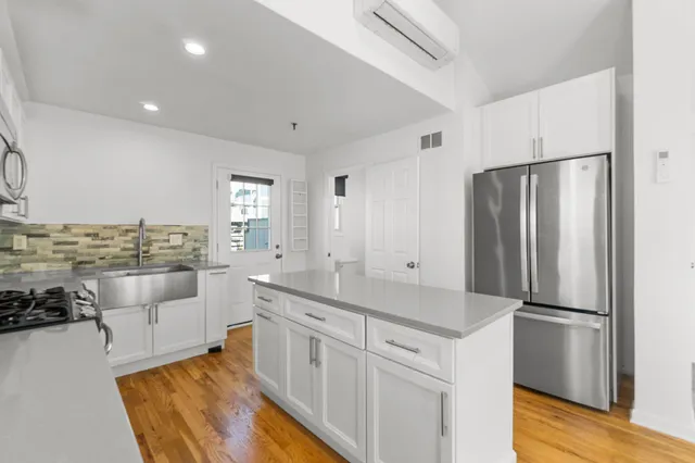 a kitchen with white cabinets and stainless steel appliances