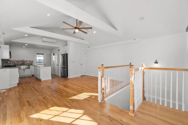 a view of a kitchen with kitchen island wooden floor and electronic appliances
