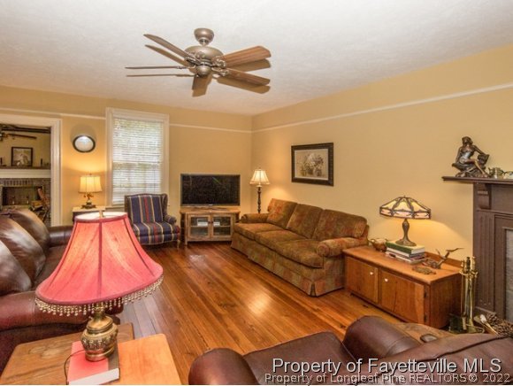 524 Carthage Street Cameron, NC 28326 - Photo 4 of 16 a living room with furniture a flat screen tv and a chandelier