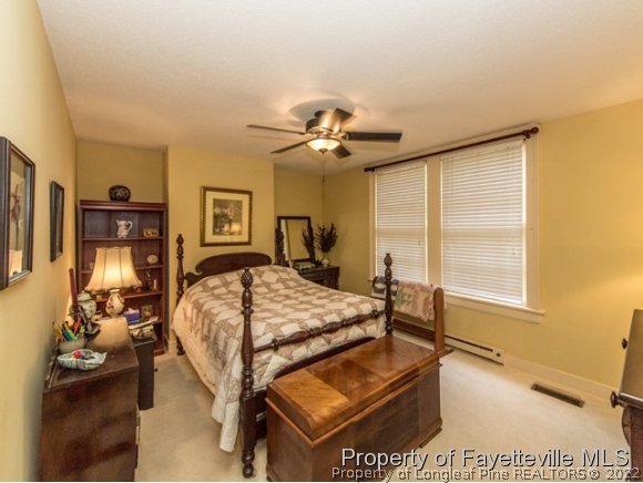 524 Carthage Street Cameron, NC 28326 - Photo 8 of 16 a bed room with a bed and a chandelier