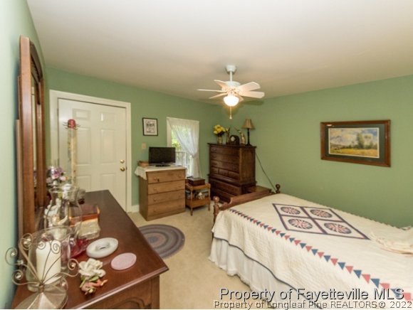 524 Carthage Street Cameron, NC 28326 - Photo 10 of 16 a bed room with a bed and a chandelier