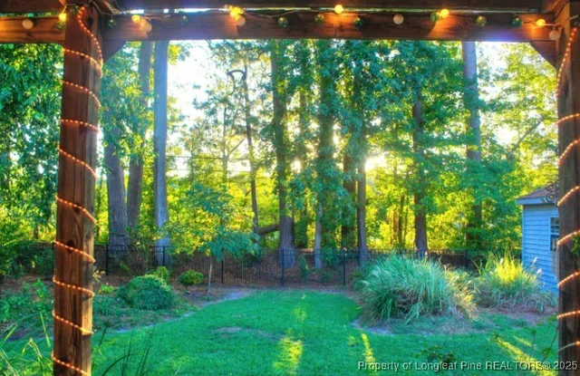 a view of a patio with table and chairs and a small yard