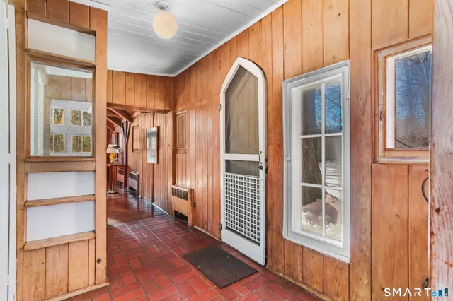 a view of a hallway with wooden floor and windows