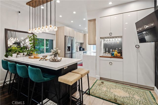 a kitchen with stainless steel appliances kitchen island granite countertop a table and chairs in it