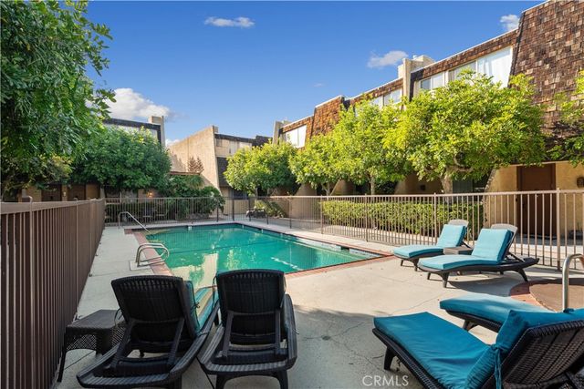 a view of a chairs and table in the back yard of the house