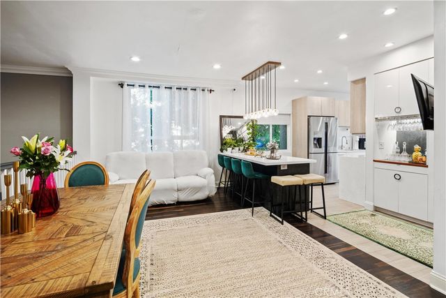 a living room with furniture a dining table and a potted plant
