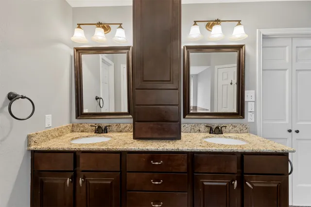 a bathroom with a granite countertop toilet sink and mirror