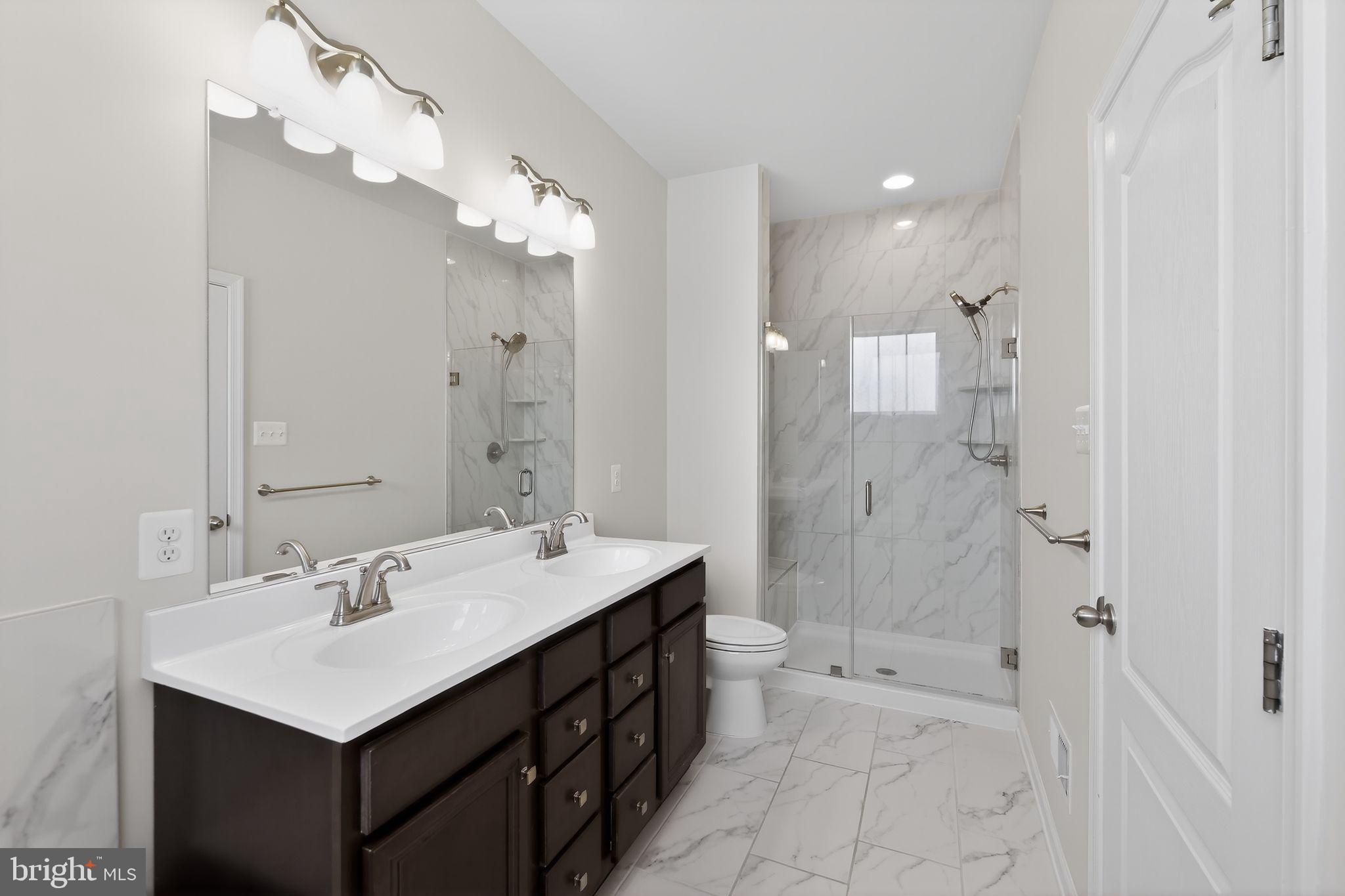1518 Ricketts Road Frederick, MD 21702 - Photo 25 of 32 a bathroom with a sink double vanity mirror and shower