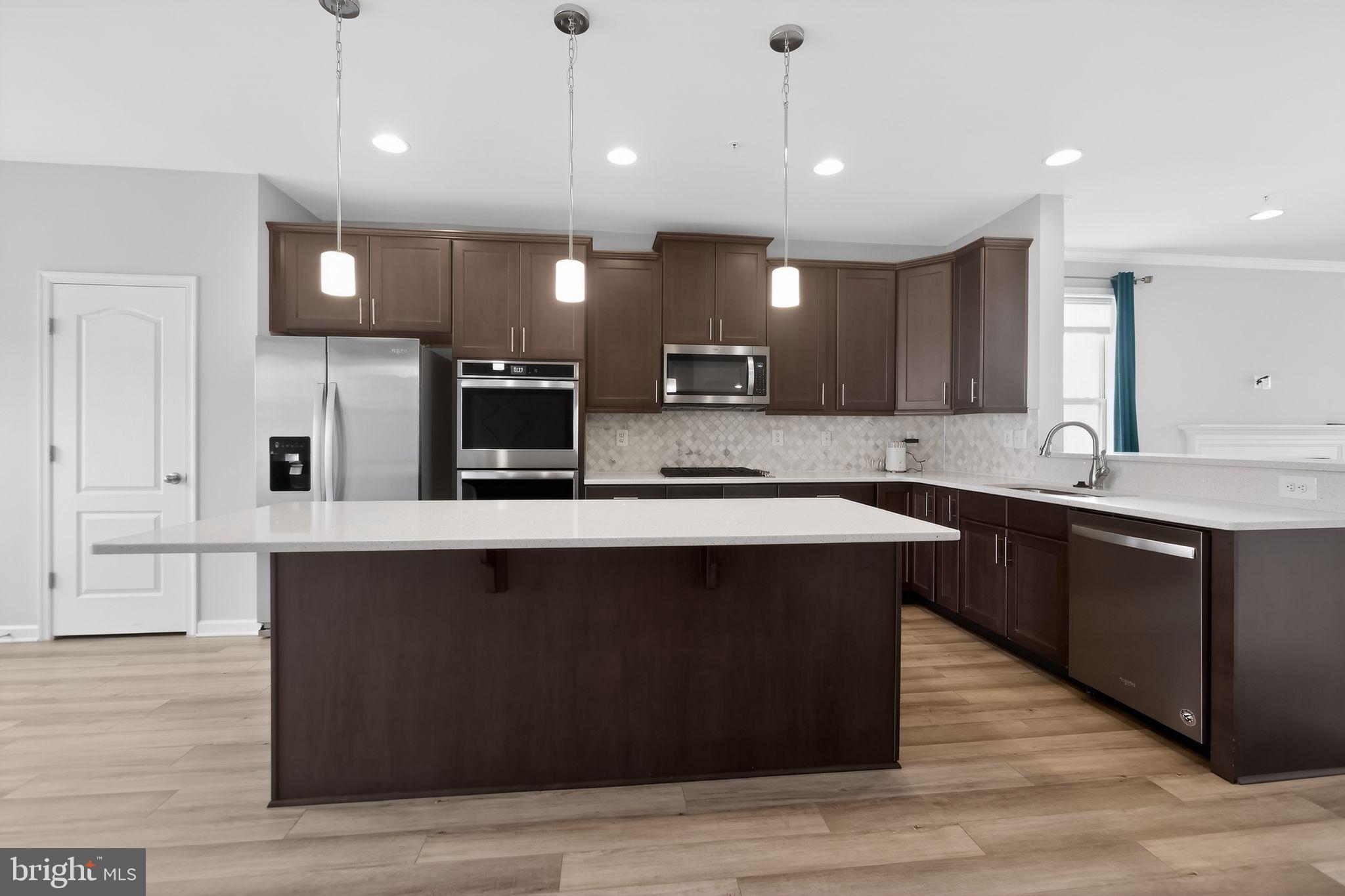 1518 Ricketts Road Frederick, MD 21702 - Photo 6 of 32 a kitchen with a center island wooden floor and a sink
