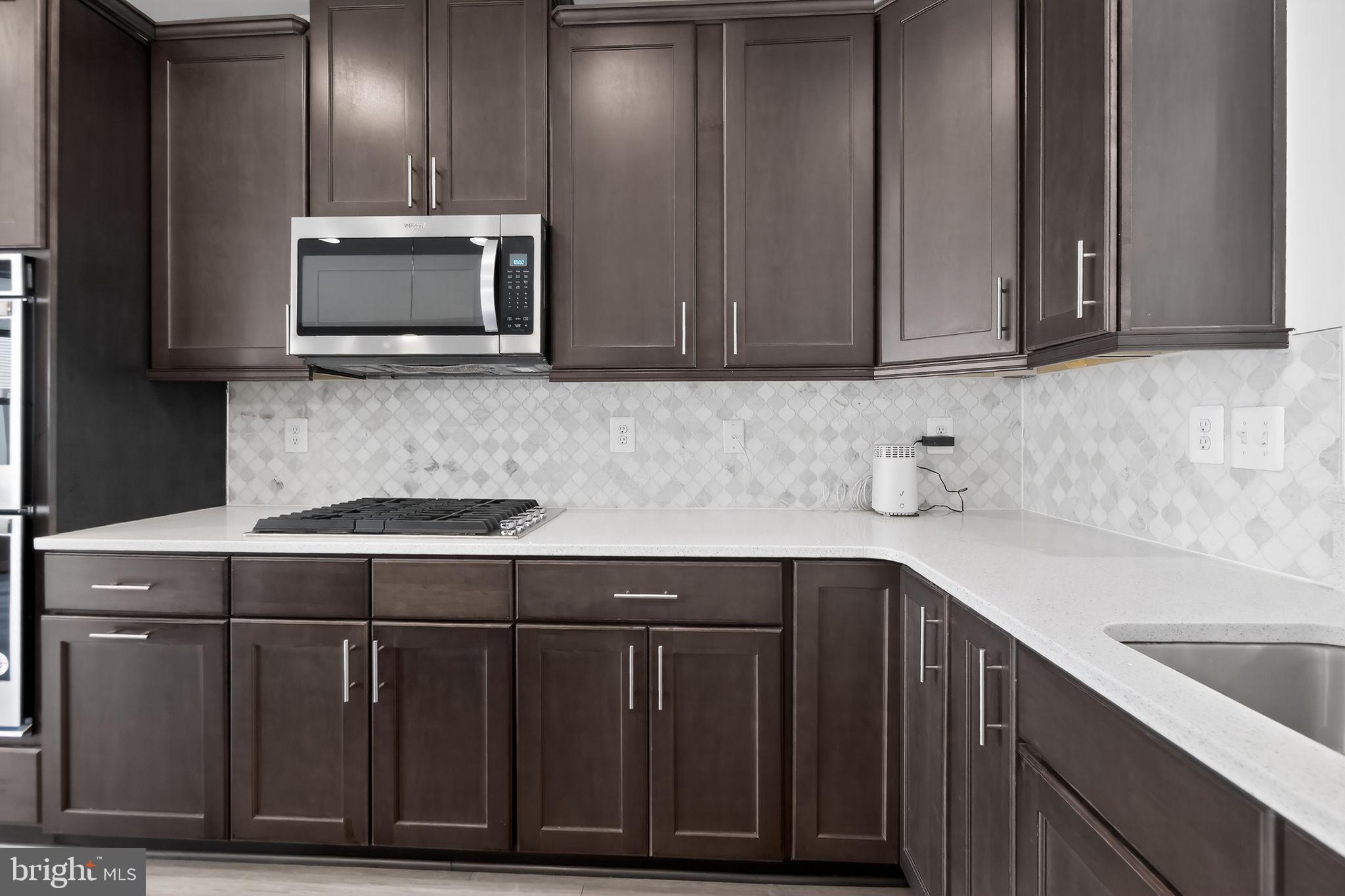 1518 Ricketts Road Frederick, MD 21702 - Photo 7 of 32 a kitchen with stainless steel appliances wooden cabinets and a sink