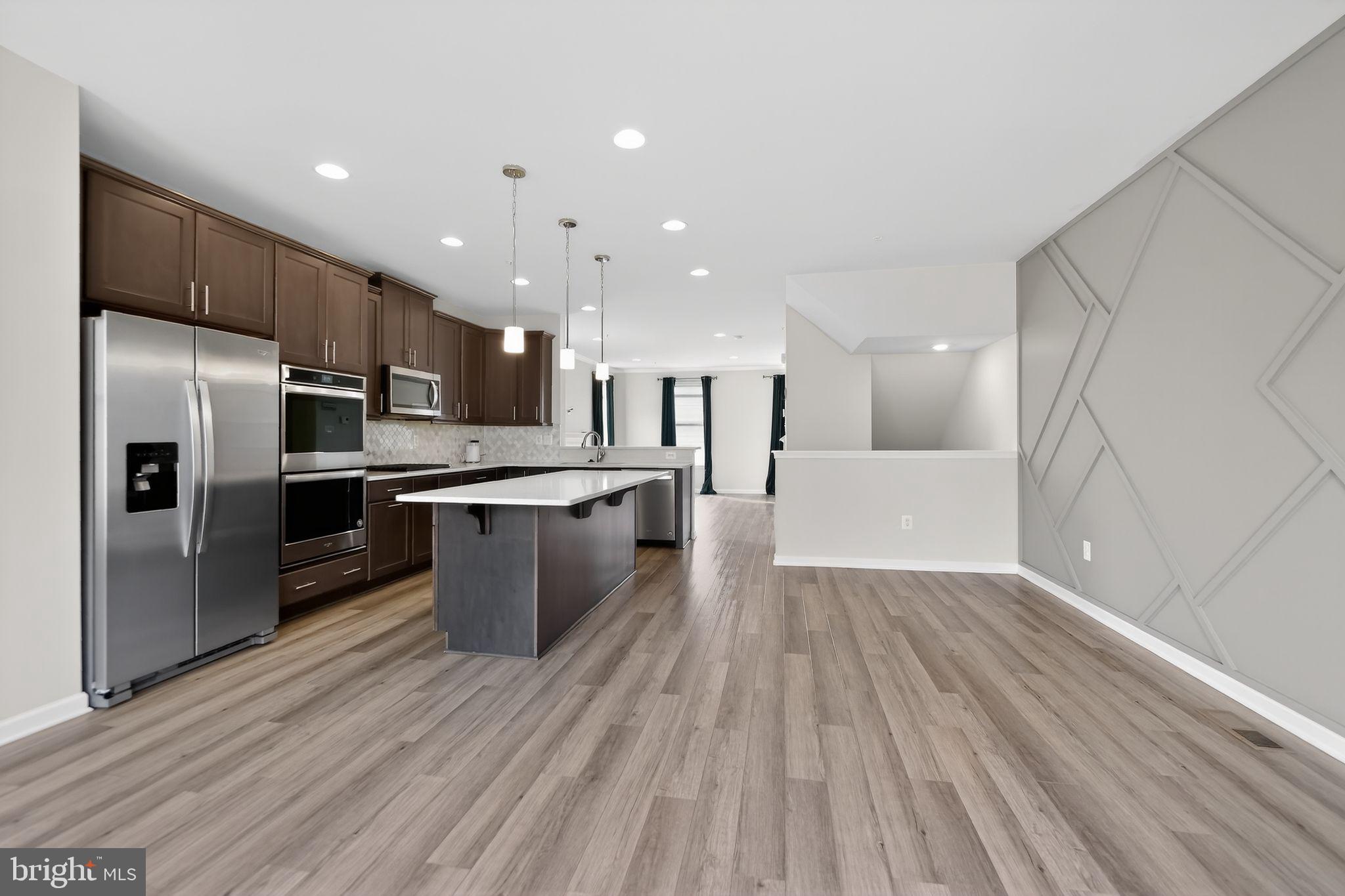 1518 Ricketts Road Frederick, MD 21702 - Photo 9 of 32 a large kitchen with kitchen island a stove a refrigerator cabinets and wooden floor