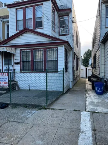 a view of a white house with large windows next to a road