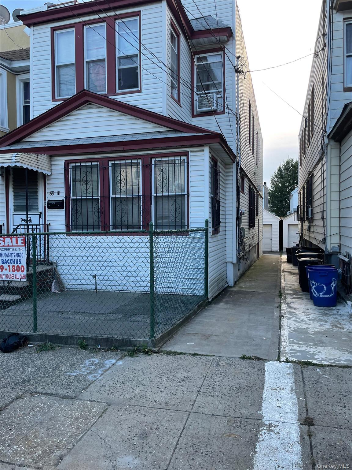 a view of a white house with large windows next to a road