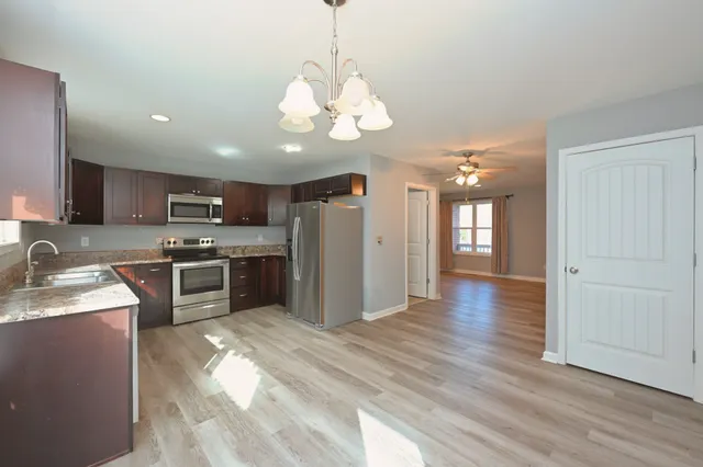 a kitchen with stainless steel appliances granite countertop a refrigerator sink and stove