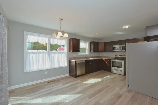 a view of a kitchen with a sink and refrigerator