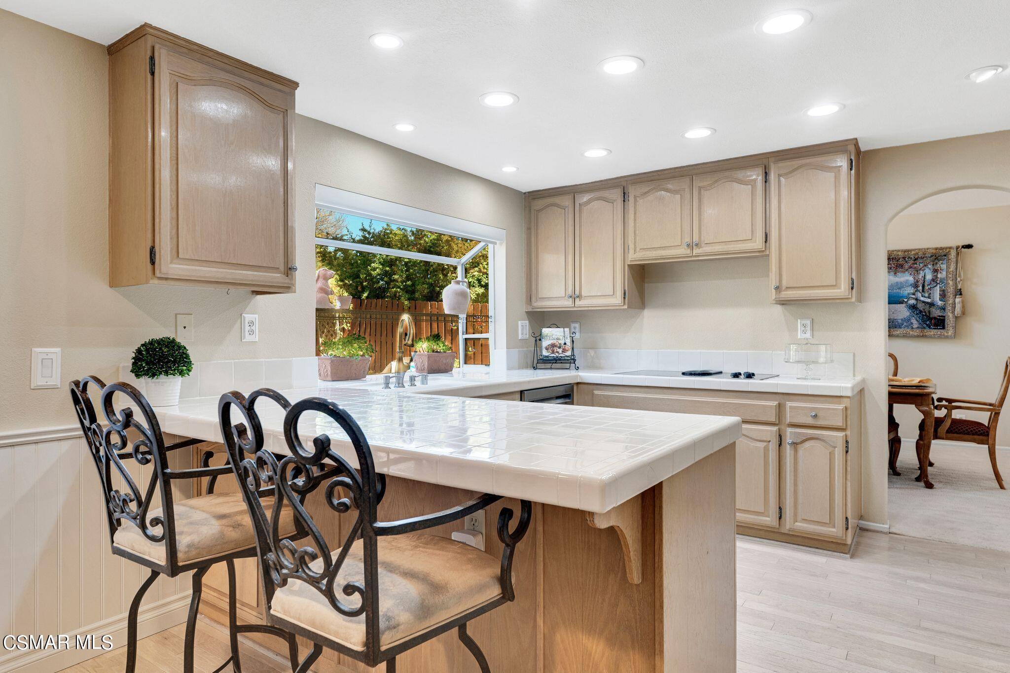 506 Innwood Road Simi Valley, CA 93065 - Photo 13 of 54 a kitchen with stainless steel appliances granite countertop a table chairs sink and cabinets