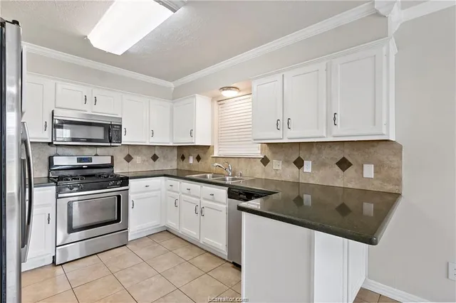 a kitchen with cabinets appliances a sink and a counter top space