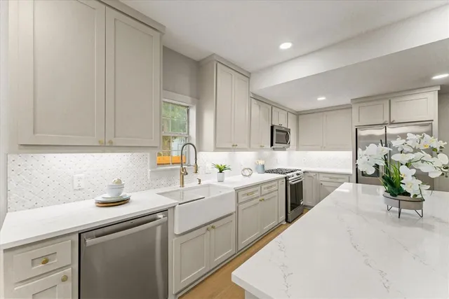 a kitchen with a sink white cabinets and counter space