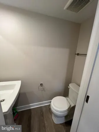 a white toilet sitting next to a white sink and vanity