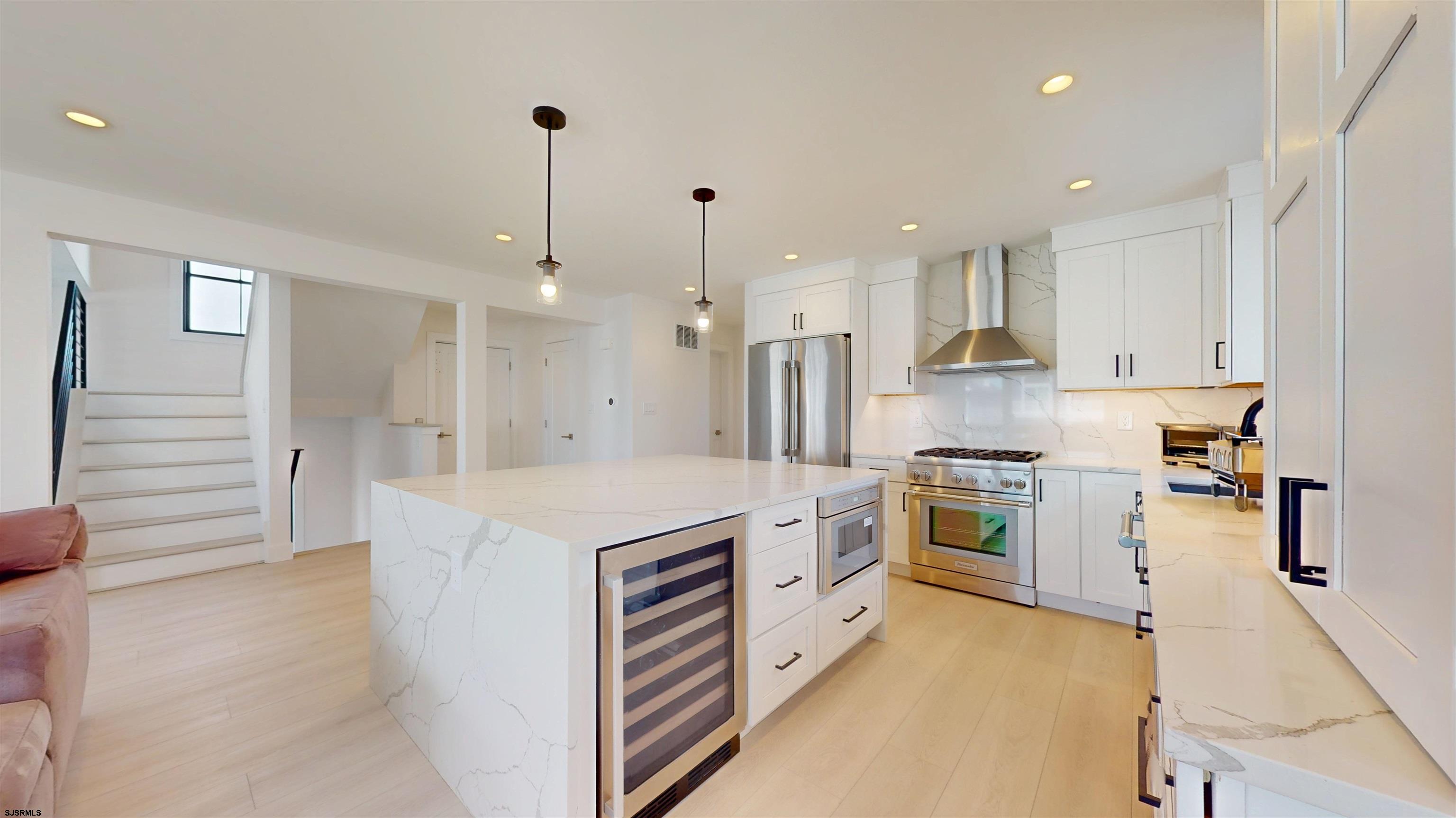342 38th Street South Brigantine, NJ 08203 - Photo 23 of 86 a kitchen with white cabinets and stainless steel appliances