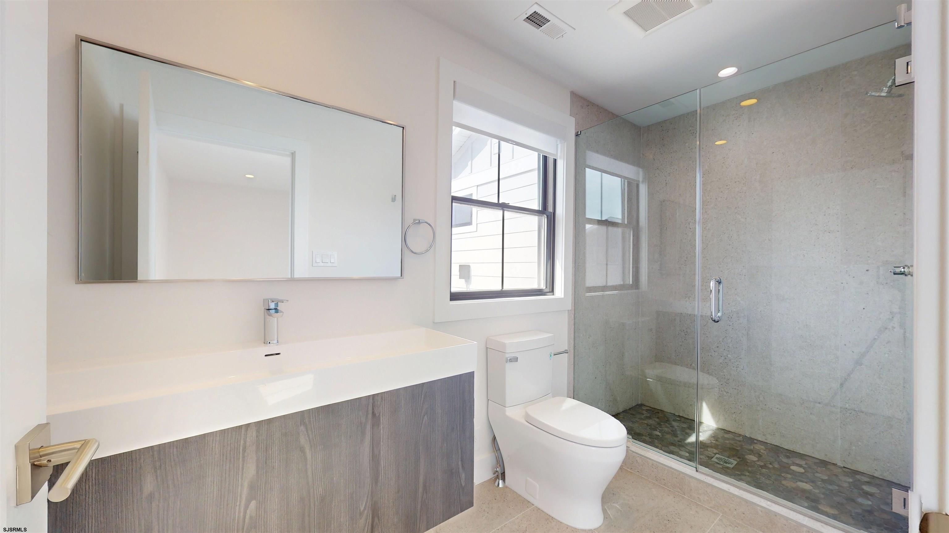 342 38th Street South Brigantine, NJ 08203 - Photo 71 of 86 a bathroom with a toilet a sink and mirror