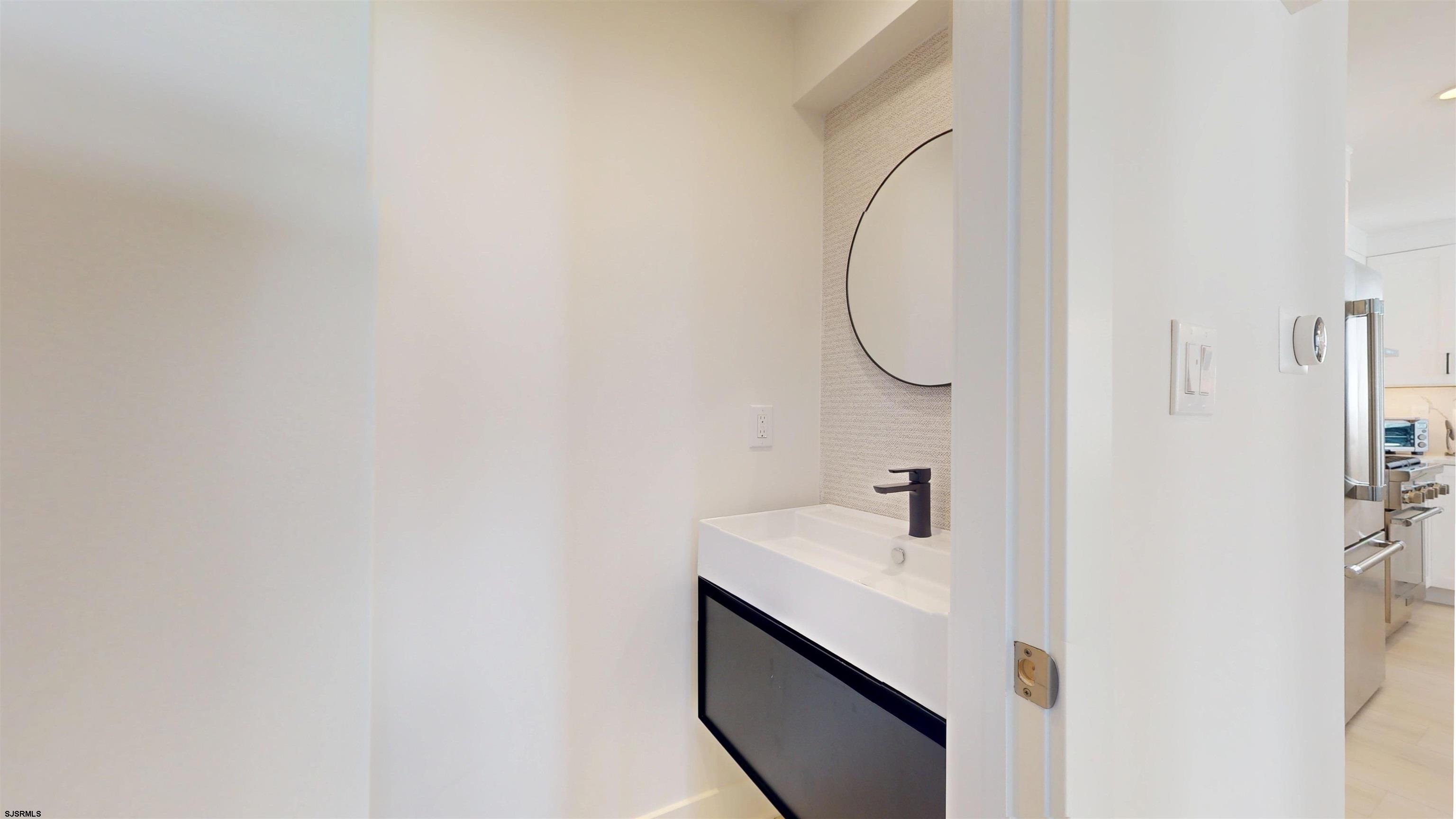 342 38th Street South Brigantine, NJ 08203 - Photo 75 of 86 a bathroom with a sink and a mirror