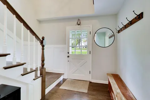 a living room with furniture a large window and a chandelier
