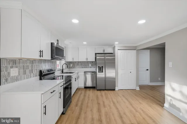 a kitchen with stainless steel appliances a refrigerator sink and cabinets