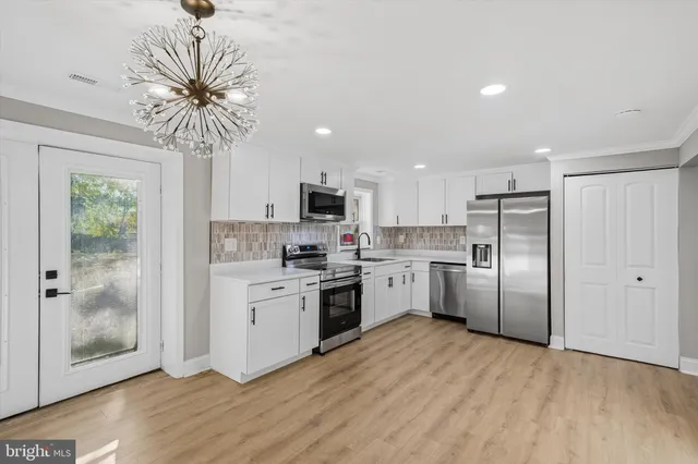 a kitchen with white cabinets and stainless steel appliances