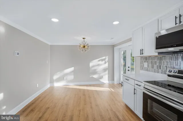 a kitchen with granite countertop a stove and a wooden floor