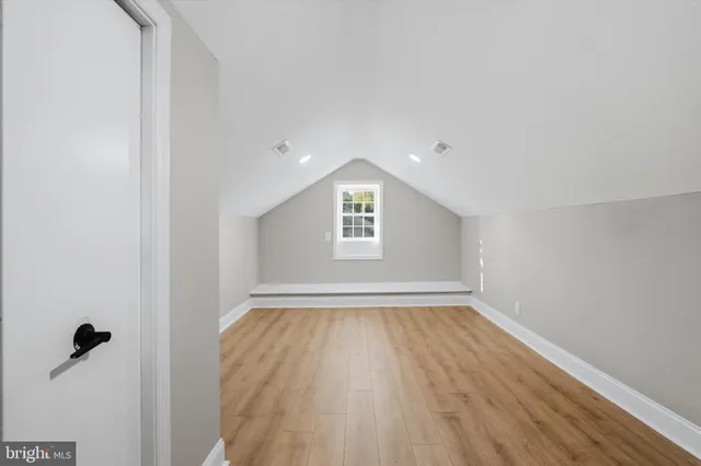 a view of a room with wooden floor and white walls