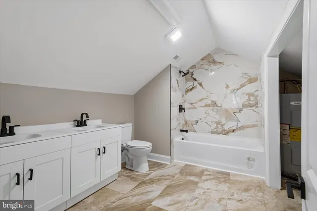 a bathroom with a toilet sink a mirror and vanity