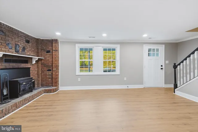 an empty room with windows and fireplace