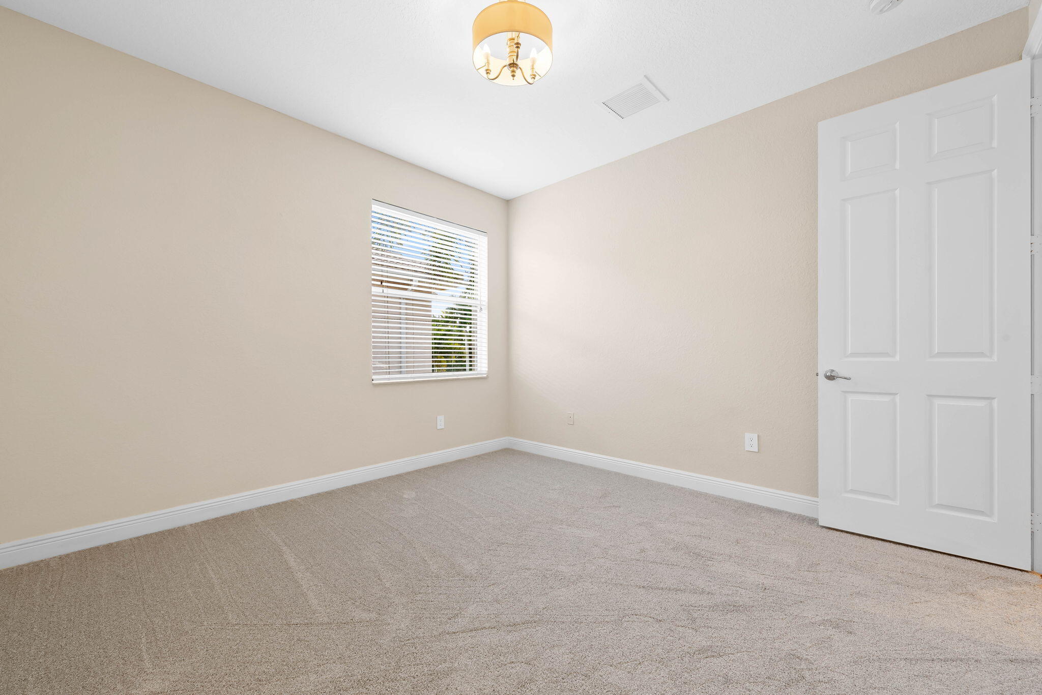 10774 Sunset Ridge Circle Boynton Beach, FL 33473 - Photo 21 of 39 an empty room with windows and chandelier