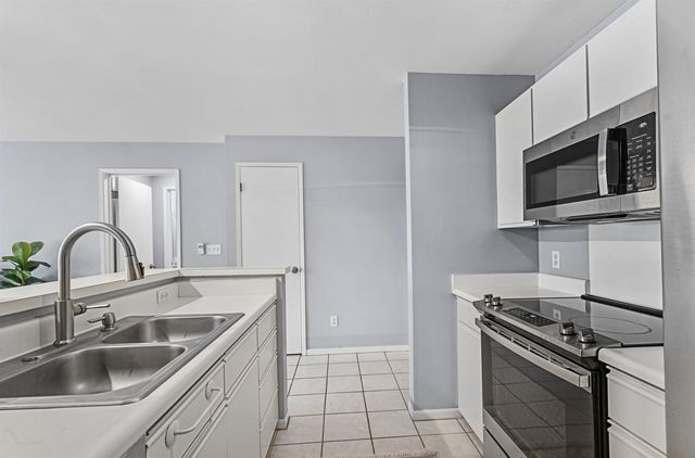 a kitchen with stainless steel appliances granite countertop a sink and a stove top oven