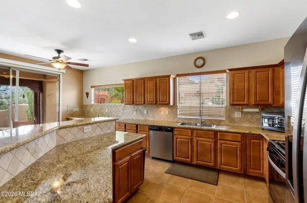 a large kitchen with stainless steel appliances granite countertop a sink and cabinets