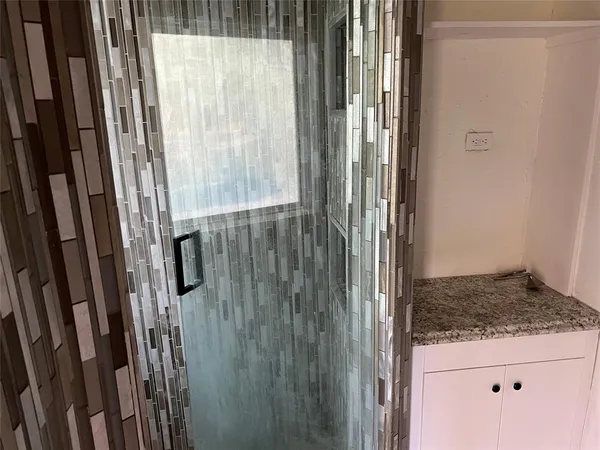 a bathroom with a granite countertop shower and a sink