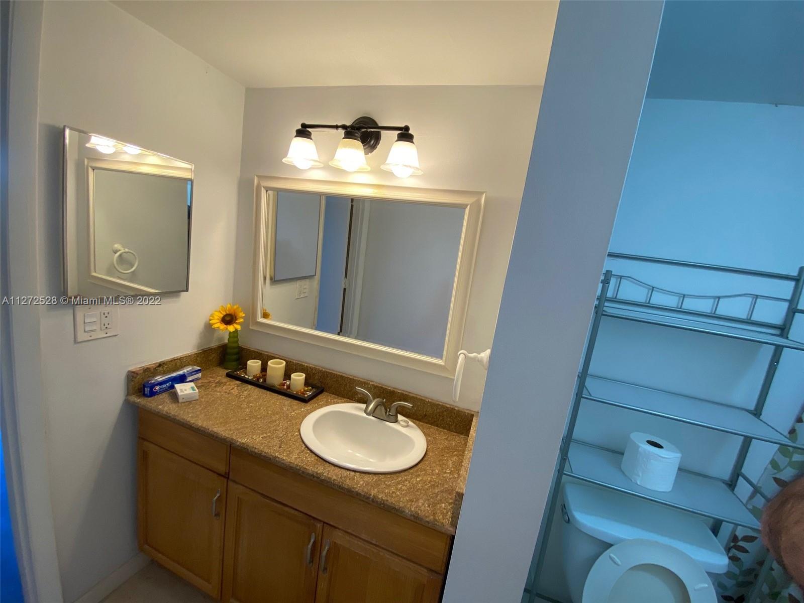 9355 Southwest 8th Street, Unit 216 Boca Raton, FL 33428 - Photo 11 of 15 a bathroom with a sink and mirror
