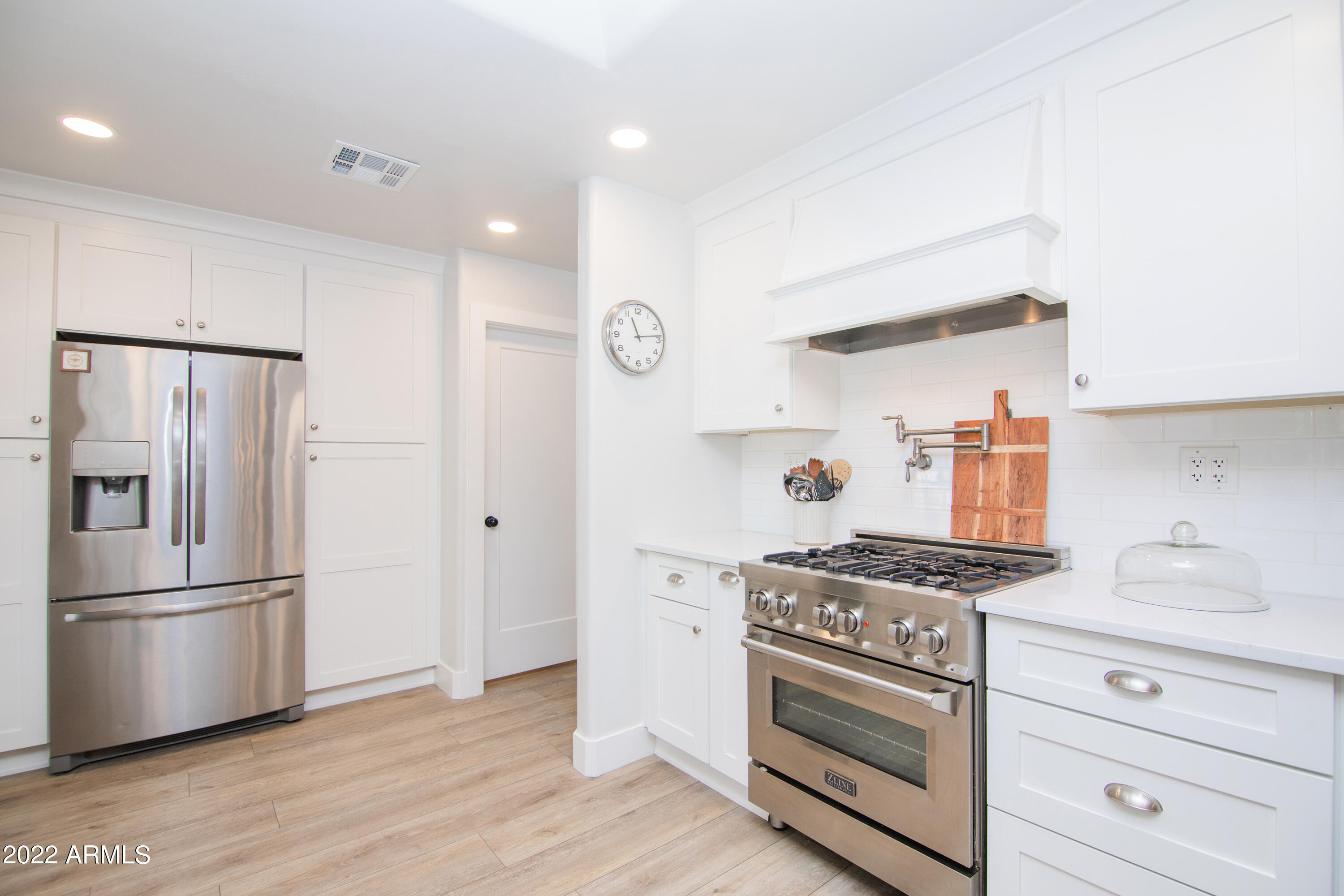 11044 North 36th Street Phoenix, AZ 85028 - Photo 16 of 49 a kitchen with stainless steel appliances a stove a refrigerator and cabinets
