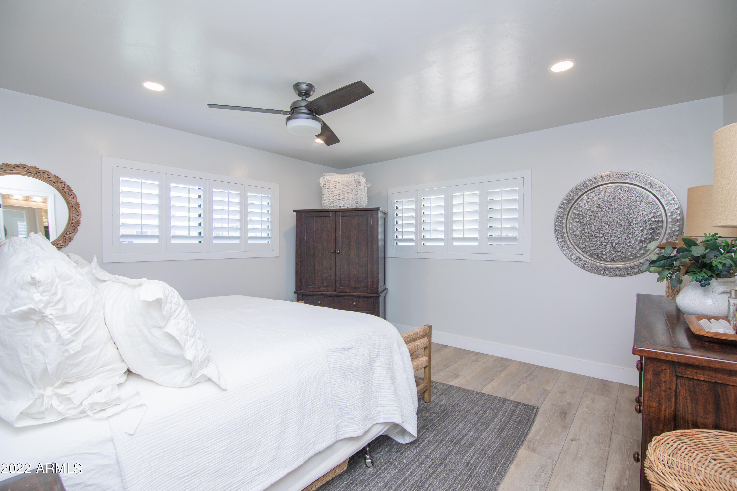 11044 North 36th Street Phoenix, AZ 85028 - Photo 23 of 49 a bedroom with a large bed and wooden floor
