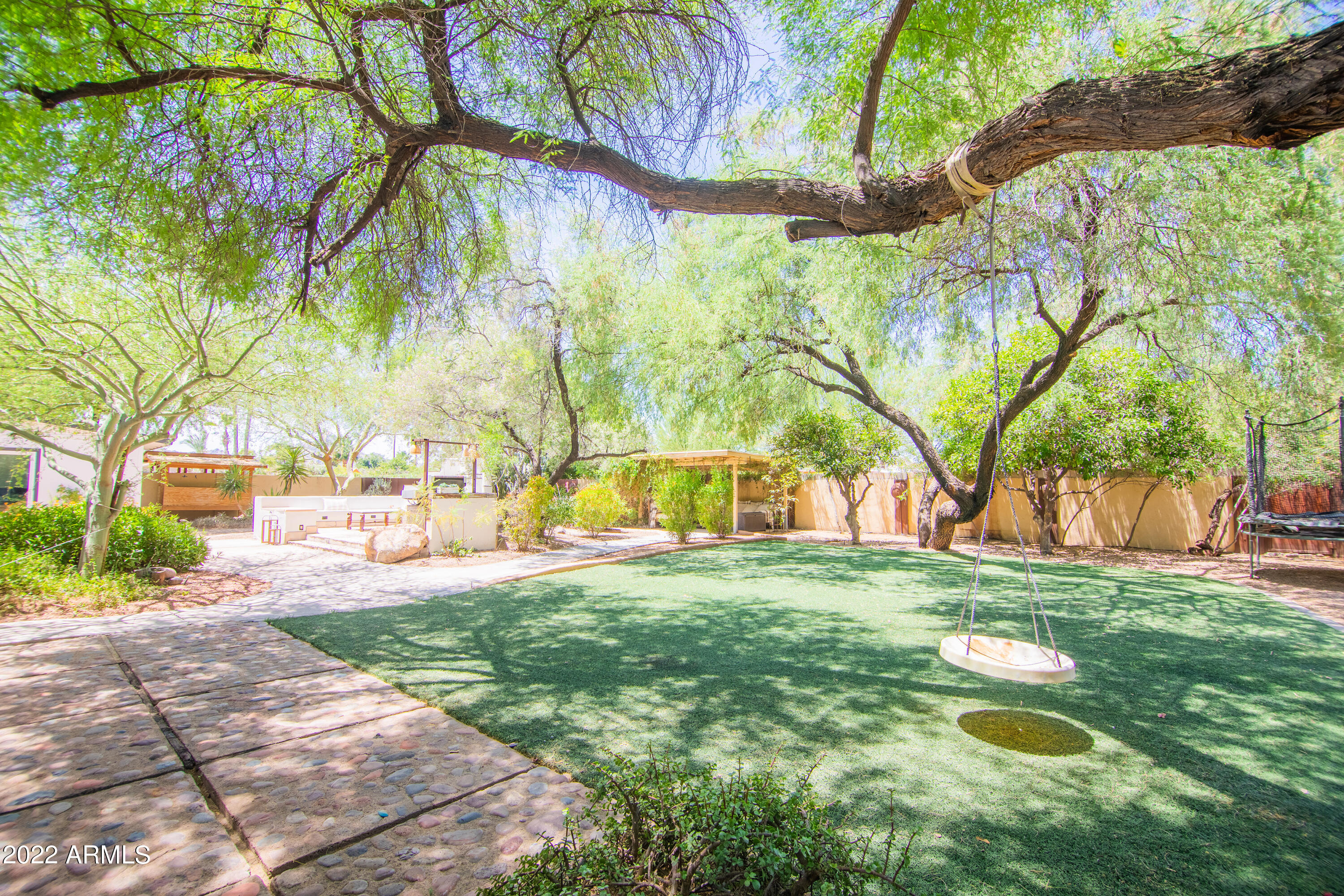 11044 North 36th Street Phoenix, AZ 85028 - Photo 36 of 49 a backyard of a house with table and chairs under an umbrella
