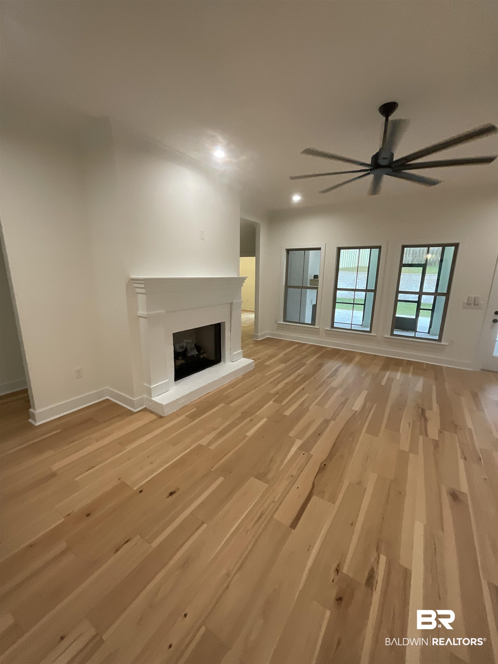 6389 Garrison Drive Daphne, AL 36527 - Photo 2 of 5 Unfurnished living room featuring ceiling fan and light wood-type flooring