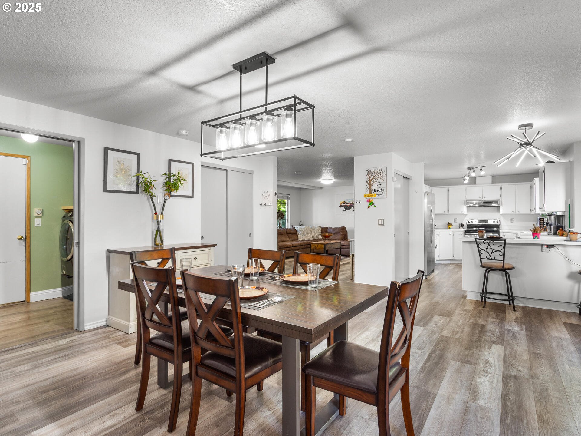 8292 Northeast Snowberry Loop Vancouver, WA 98664 - Photo 16 of 48 a view of a dining room with furniture wooden floor and chandelier
